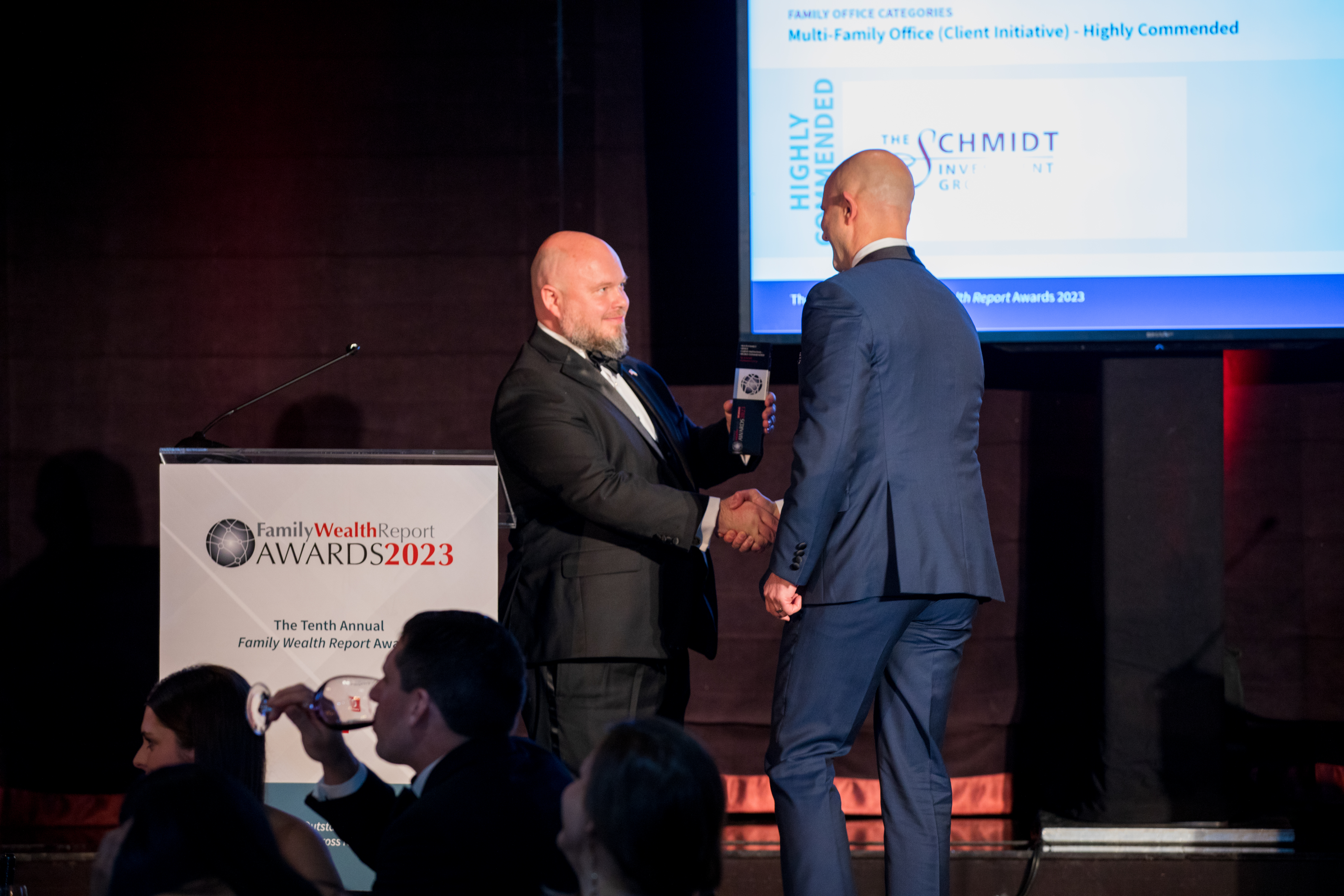 Marcin Schmidt accepting FWR award, shaking hands with presenter on stage